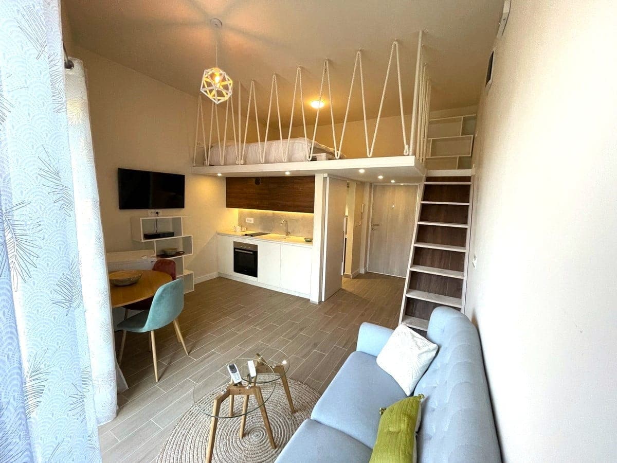 Интерьер квартиры-студии с мезонином, кухней и зоной отдыха в Тивате, Черногория. Современная мебель и светлый дизайн.