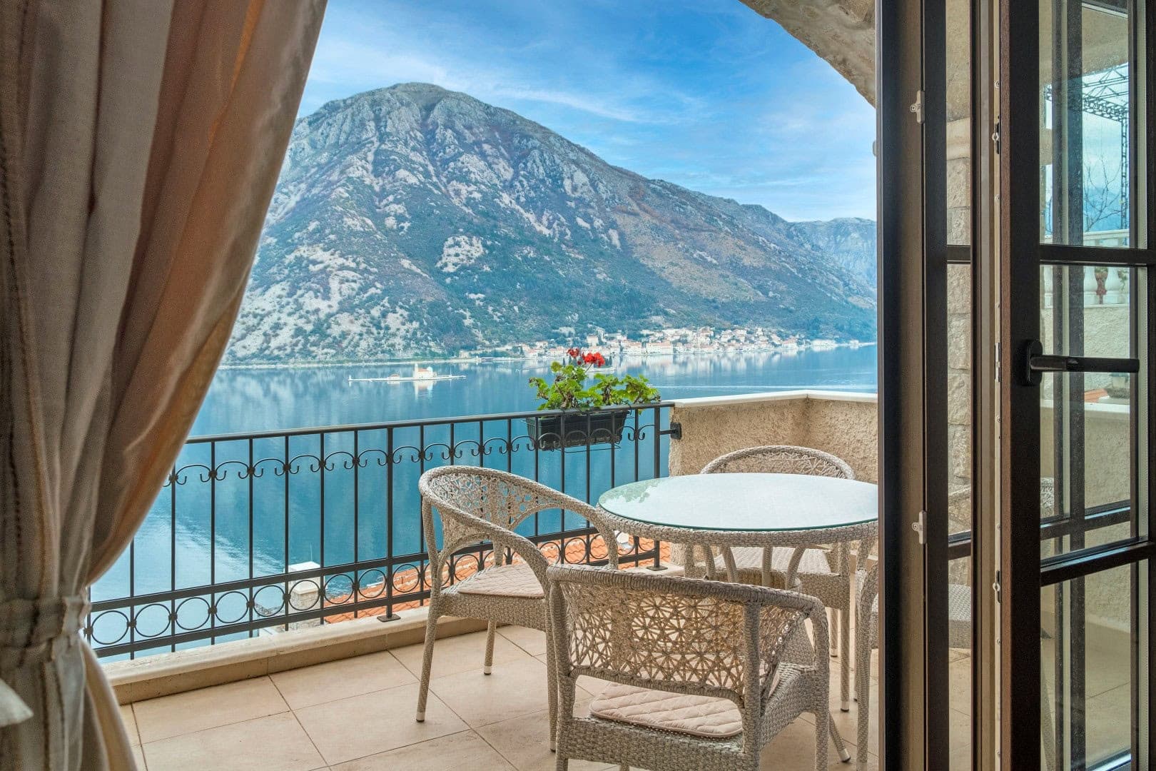 Терраса с плетеной мебелью и видом на Которский залив и горы, квартира в Костанице, Черногория.