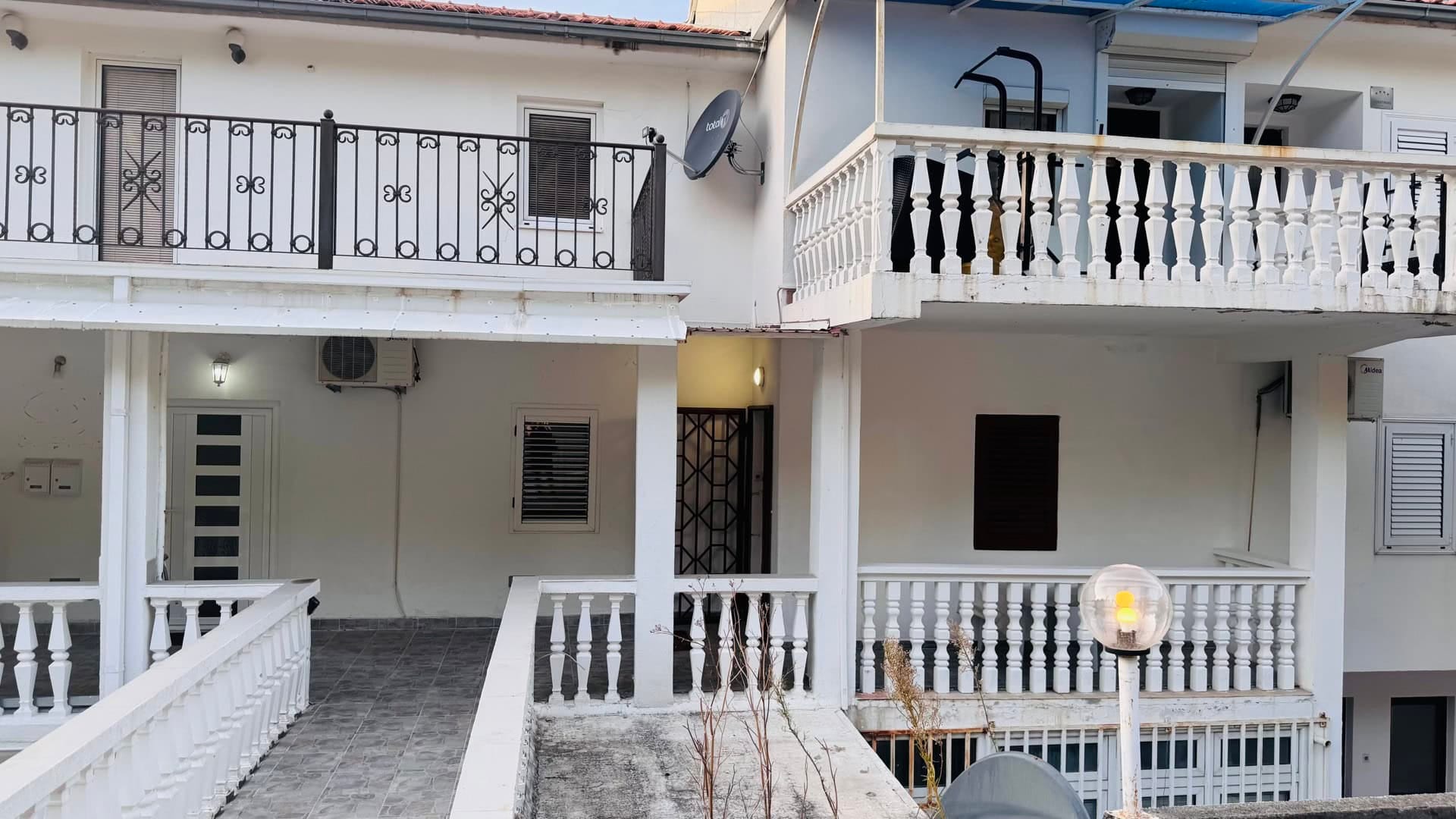 Fasada kuće sa terasama i balustradama u Svetom Stefanu, Crna Gora. Ulaz u apartmane sa spoljašnjim stepeništem.