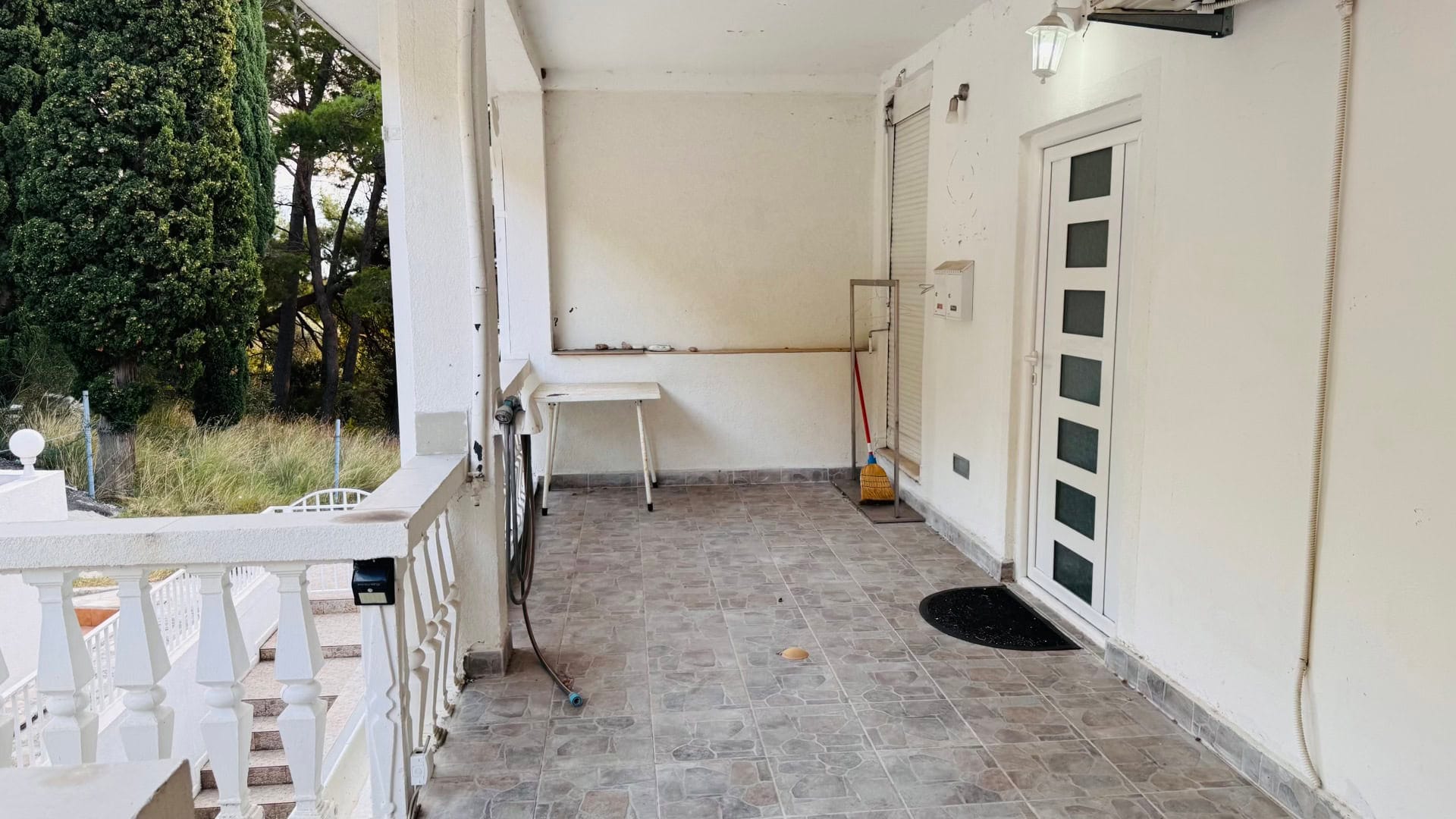 Prostrana terasa sa pločastim podom i balustradom u stanu na letovalištu Sveti Stefan, Crna Gora.