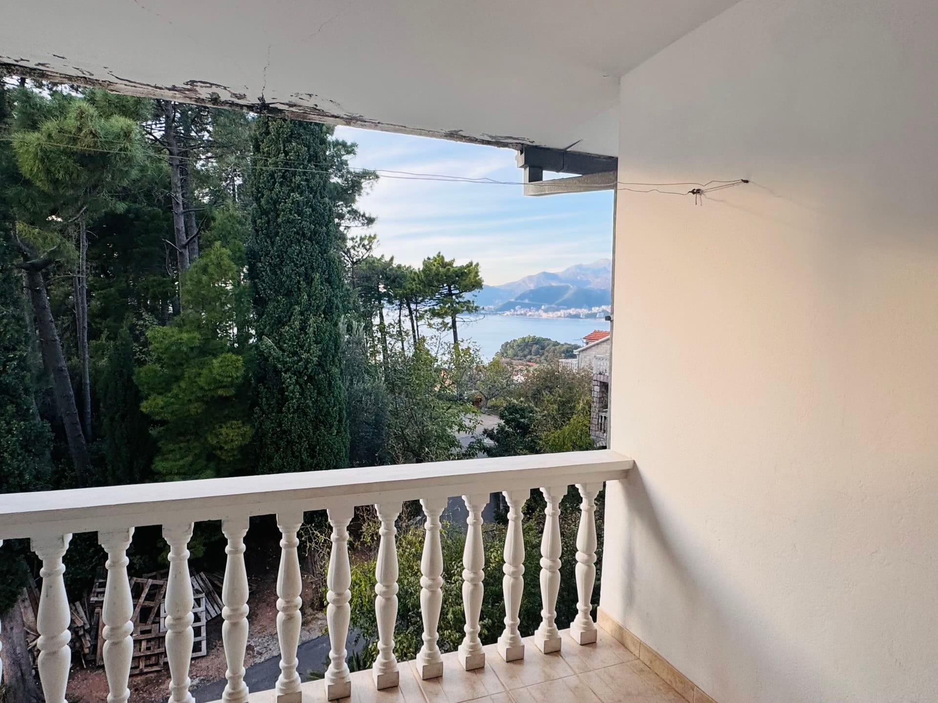 Balkon sa balustradom i panoramskim pogledom na more i planine u stanu na letovalištu Sveti Stefan, Crna Gora.