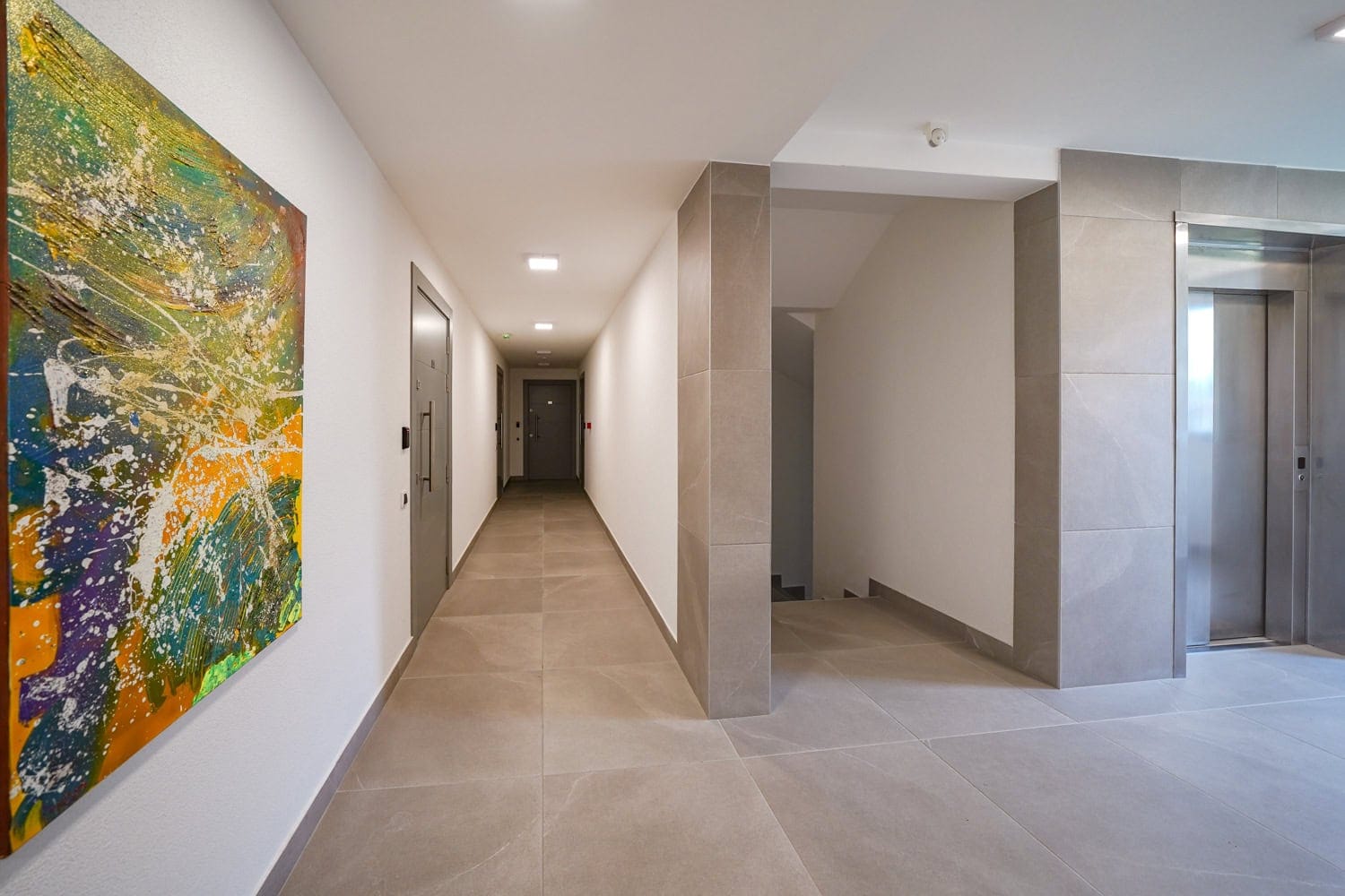 Moderan hodnik sa liftom i oblogom od porcelanskog kamena u stambenom kompleksu u gradu Tivat, Crna Gora.