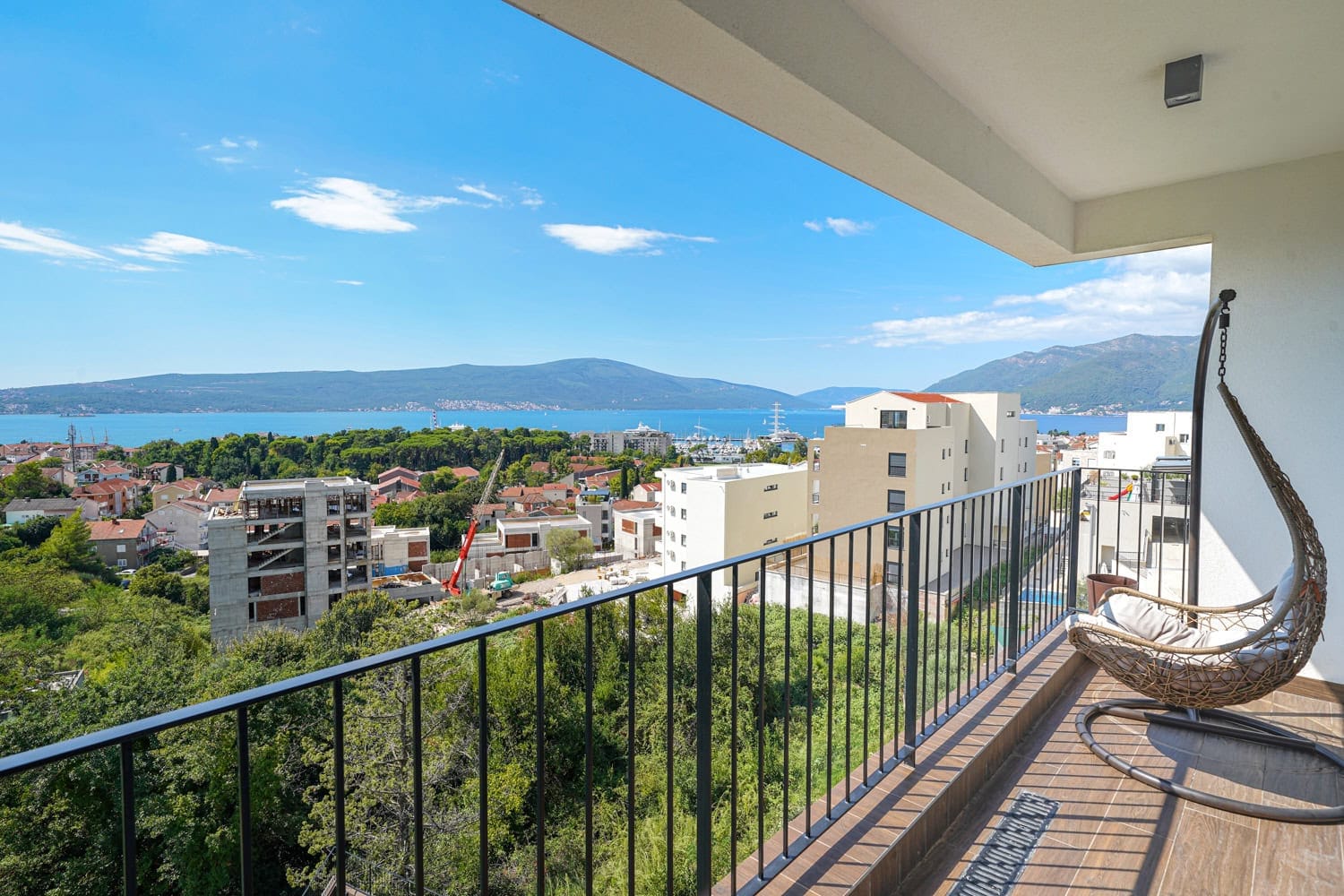 Balkon sa pletenom visećom foteljom i panoramskim pogledom na more i grad Tivat, Crna Gora. Stan br. 2351.