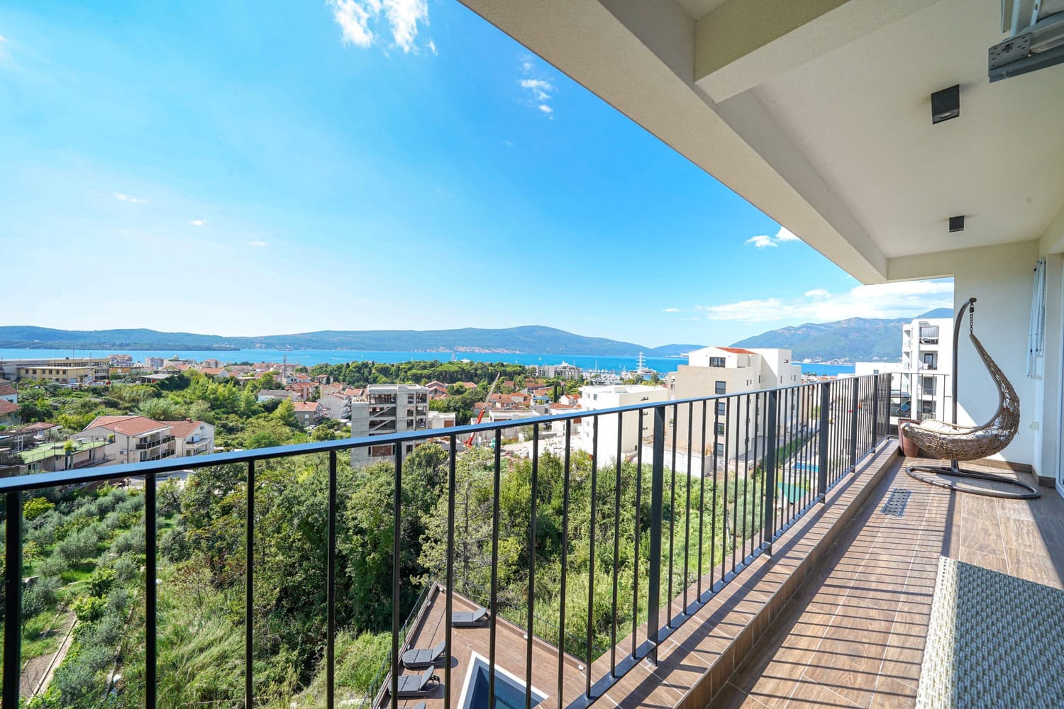 Balkon stana u Tivtu, Crna Gora, sa panoramskim pogledom na more, planine i visećom foteljom-kokonom.