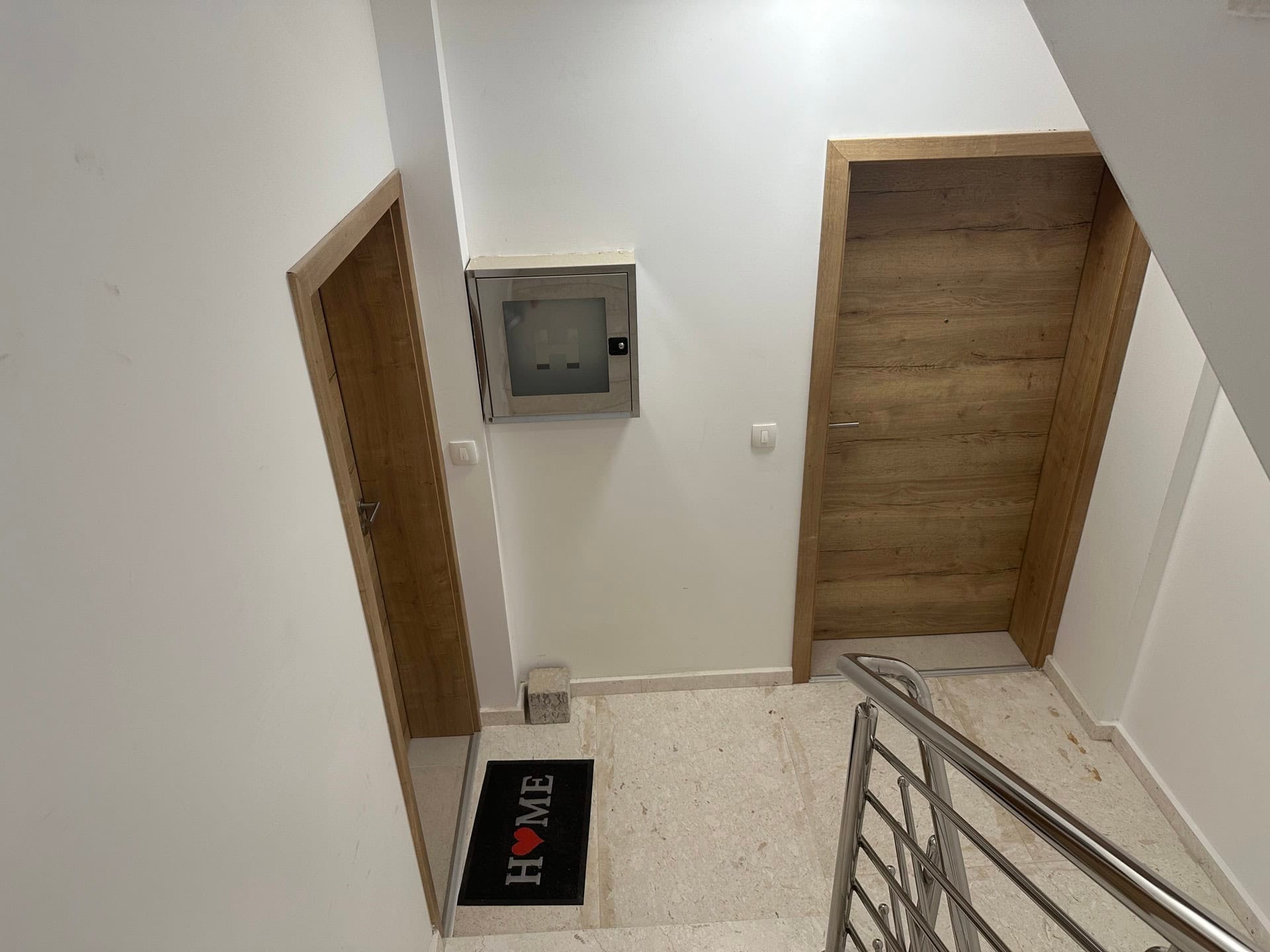 Stepenišni podest sa unutrašnjim vratima u savremenom stambenom kompleksu, Krašići, Crna Gora.