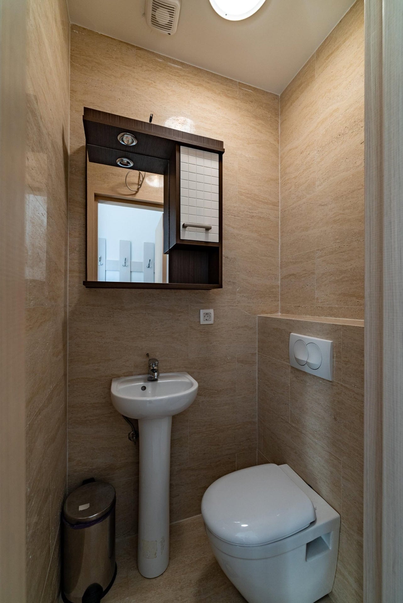 Modernes Badezimmer mit weißer Sanitärkeramik und beigen Fliesen in einer Wohnung in Pržno, Montenegro.