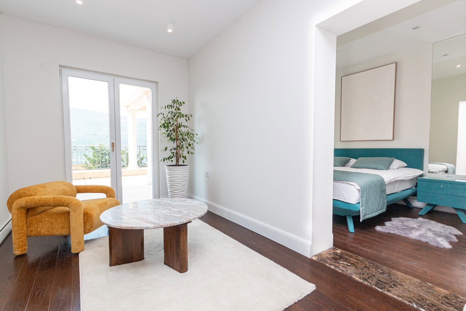 Гостиная с желтым креслом и видом на море в ЖК Кумбор, Черногория: современный интерьер с кроватью и террасой.