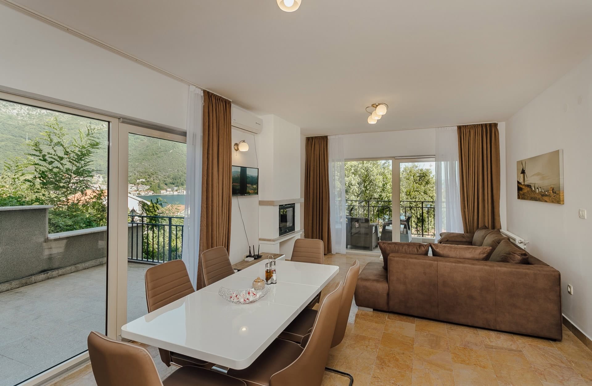 Wohnzimmer mit Essbereich und Panoramablick auf das Meer in einer Wohnung in Kamenari, Montenegro. Moderne Möbel und Terrasse.