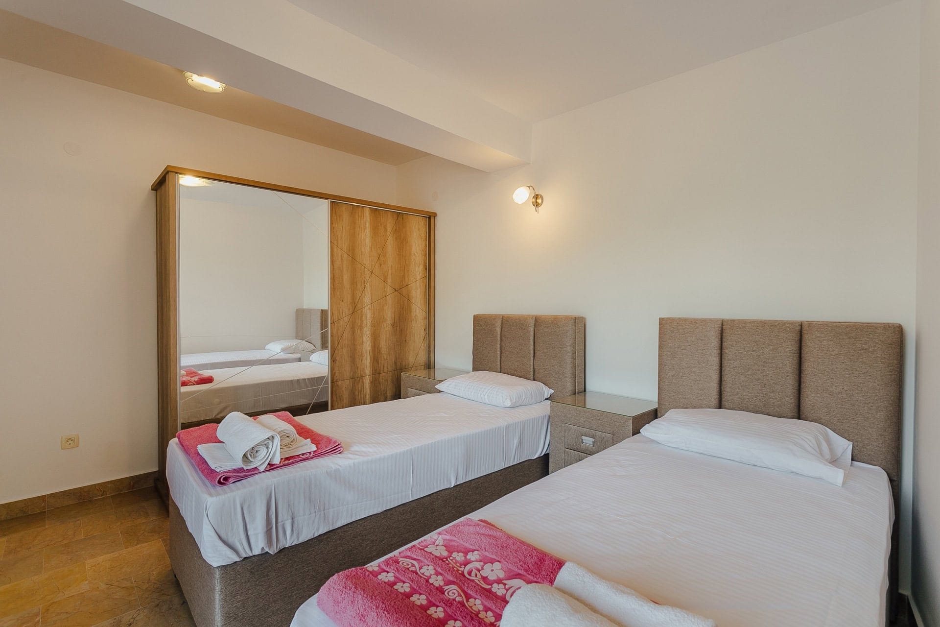 Schlafzimmer mit zwei Betten und Spiegelschrank in einer Wohnung zum Verkauf, Kamenari, Montenegro.