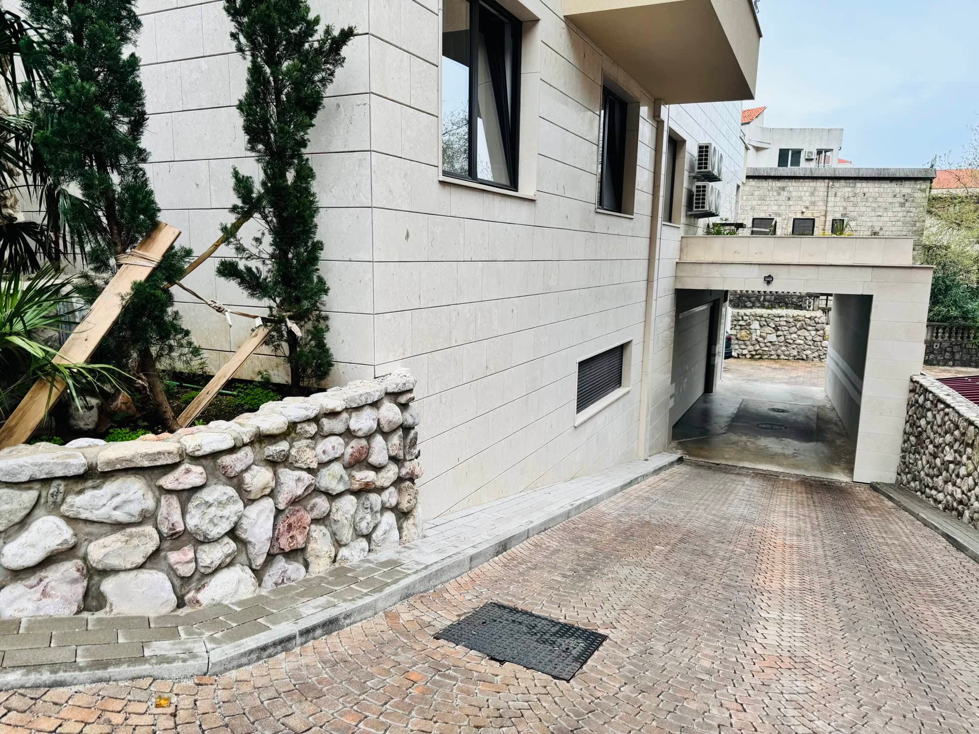Bečići, Karadağ’da taş kaplamalı ve yer altı otopark girişli modern konut binası.