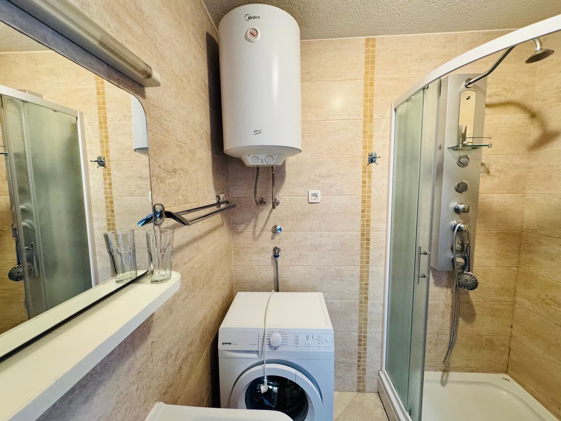 Bathroom in an apartment in Budva, Montenegro: shower cabin, Gorenje washing machine, and Midea water heater.