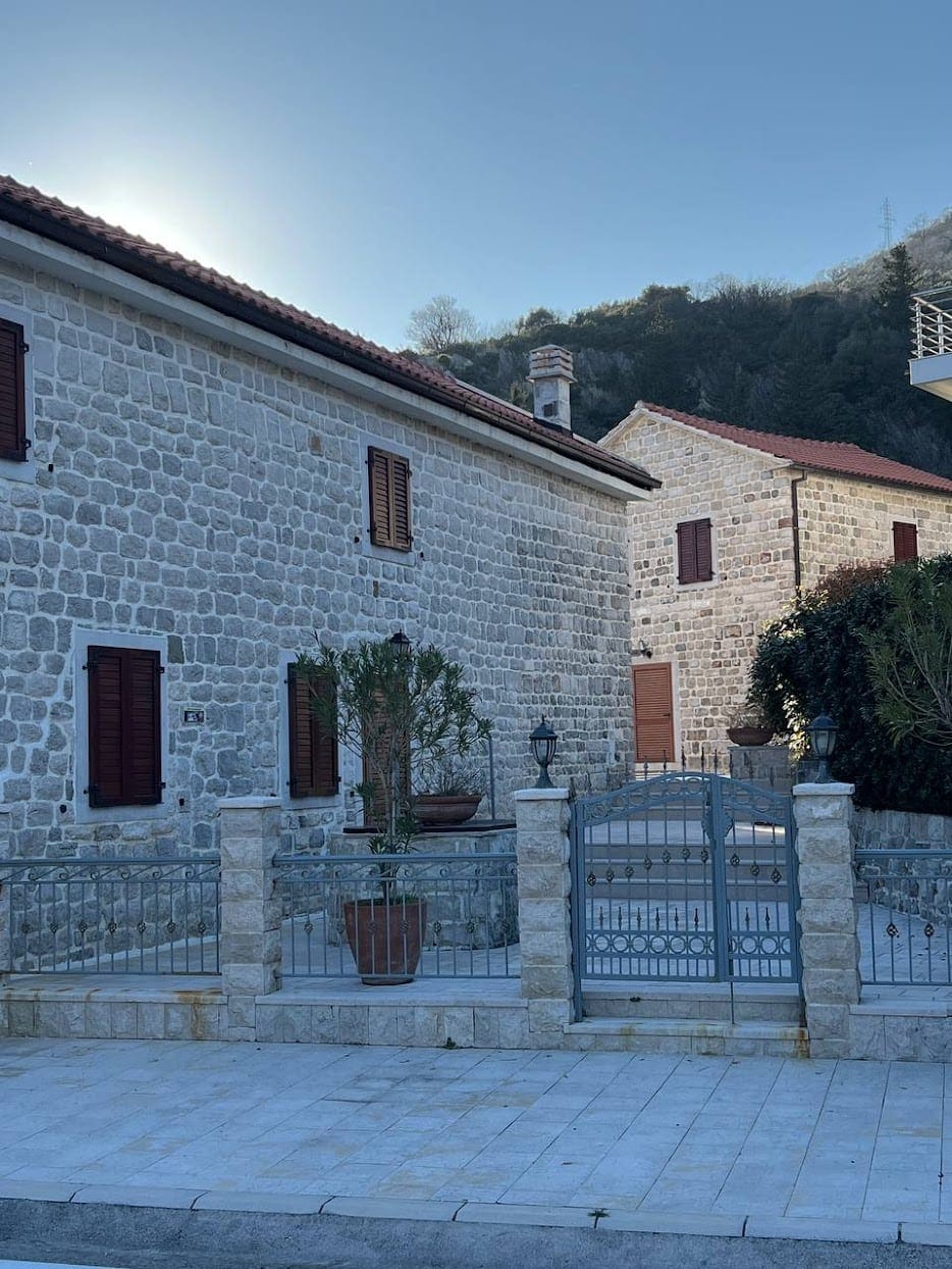 Traditionelle Steinvilla in Kamenari, Montenegro: Fassade aus Naturstein, schmiedeeisernes Tor und gemütlicher Innenhof.