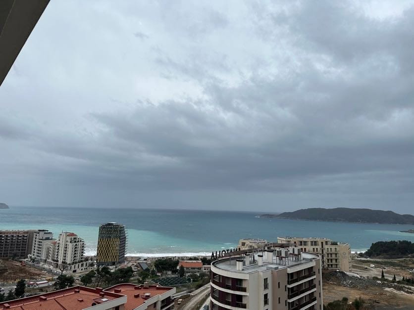 Panoramski pogled na more i plažu Bečići, Crna Gora, sa balkona modernog stana u stambenom kompleksu.
