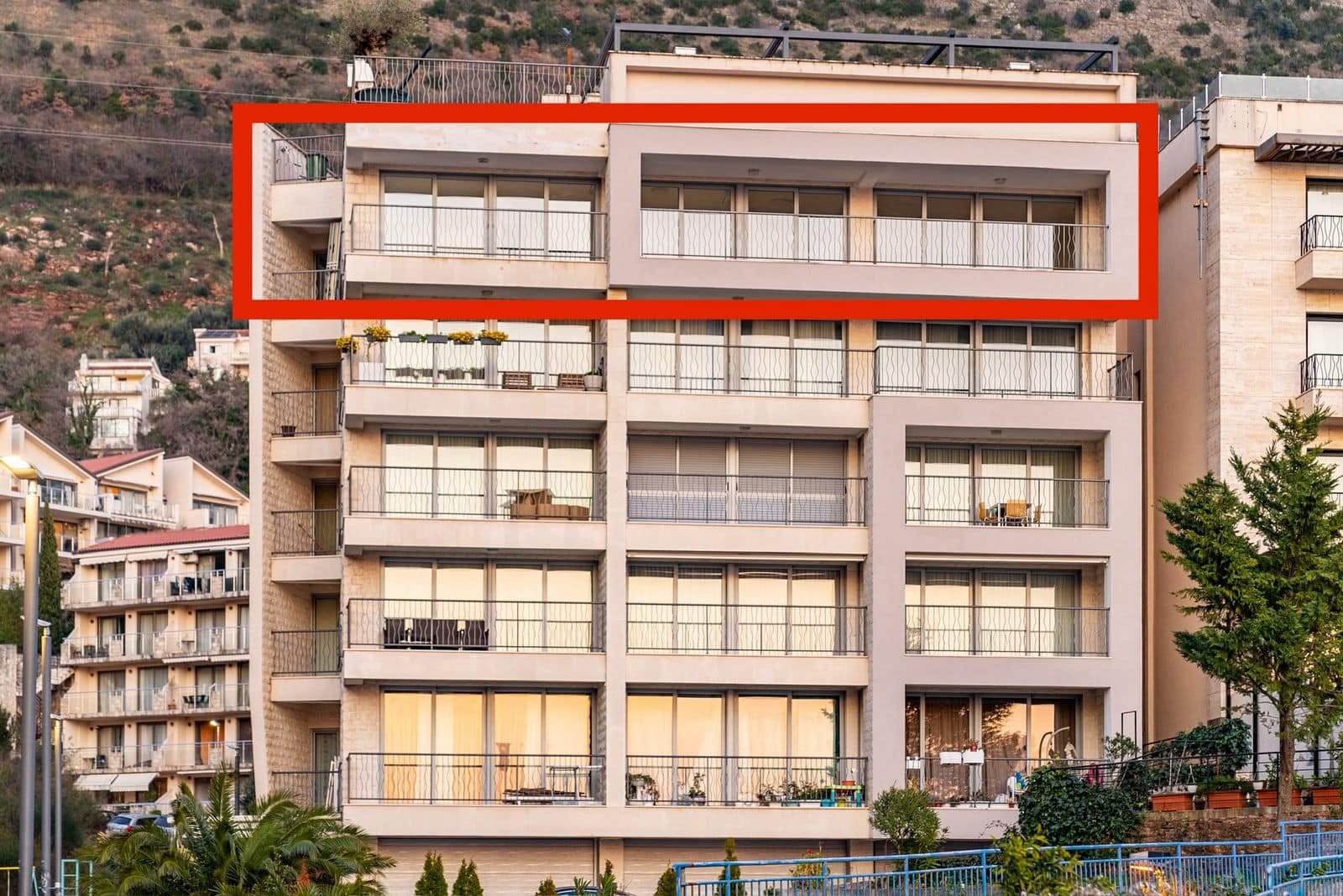 Modernes Mehrfamilienhaus in Pržno, Montenegro, mit hervorgehobenem Penthouse und Panoramabalkonen an der Fassade.