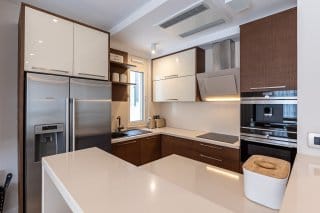 Современная кухня на вилле в Бечичи, Черногория: встроенная техника, глянцевые фасады и светлая столешница.