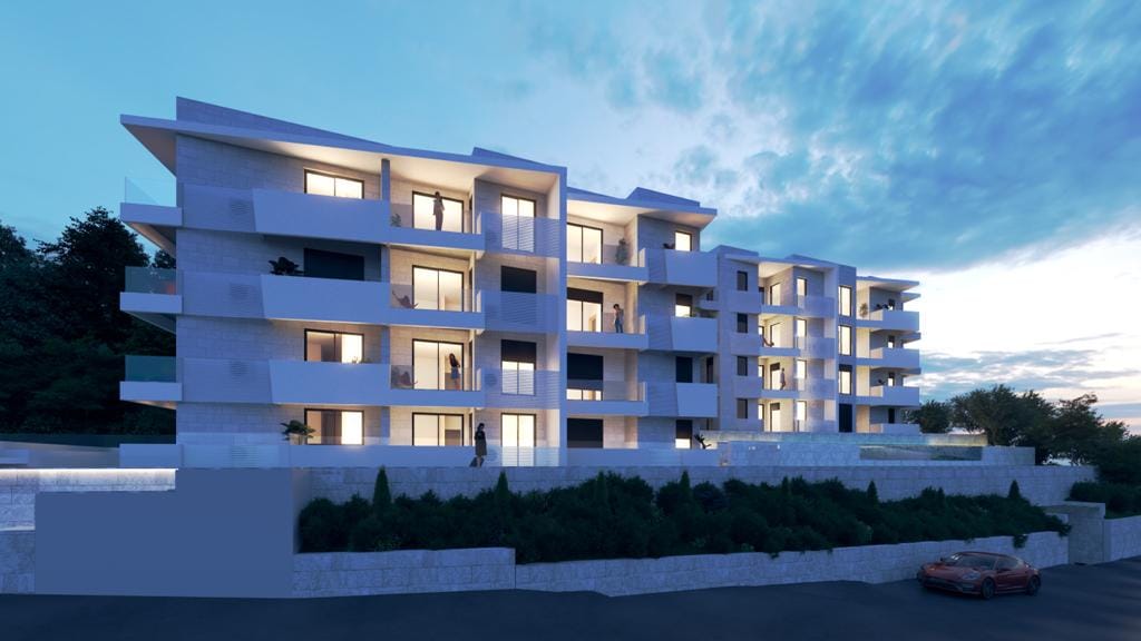 Moderner Wohnkomplex in Petrovac, Montenegro: Gebäudefassade mit Terrassen, Panoramafenstern und abendlicher Beleuchtung