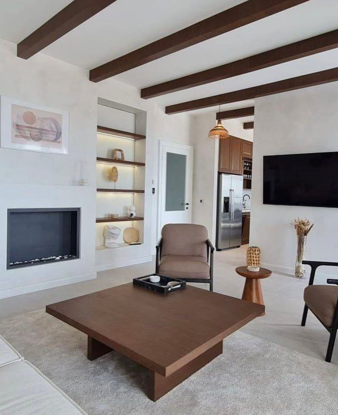 Villa living room in Budva, Montenegro: modern interior with a fireplace, wooden beams, and stylish furniture.