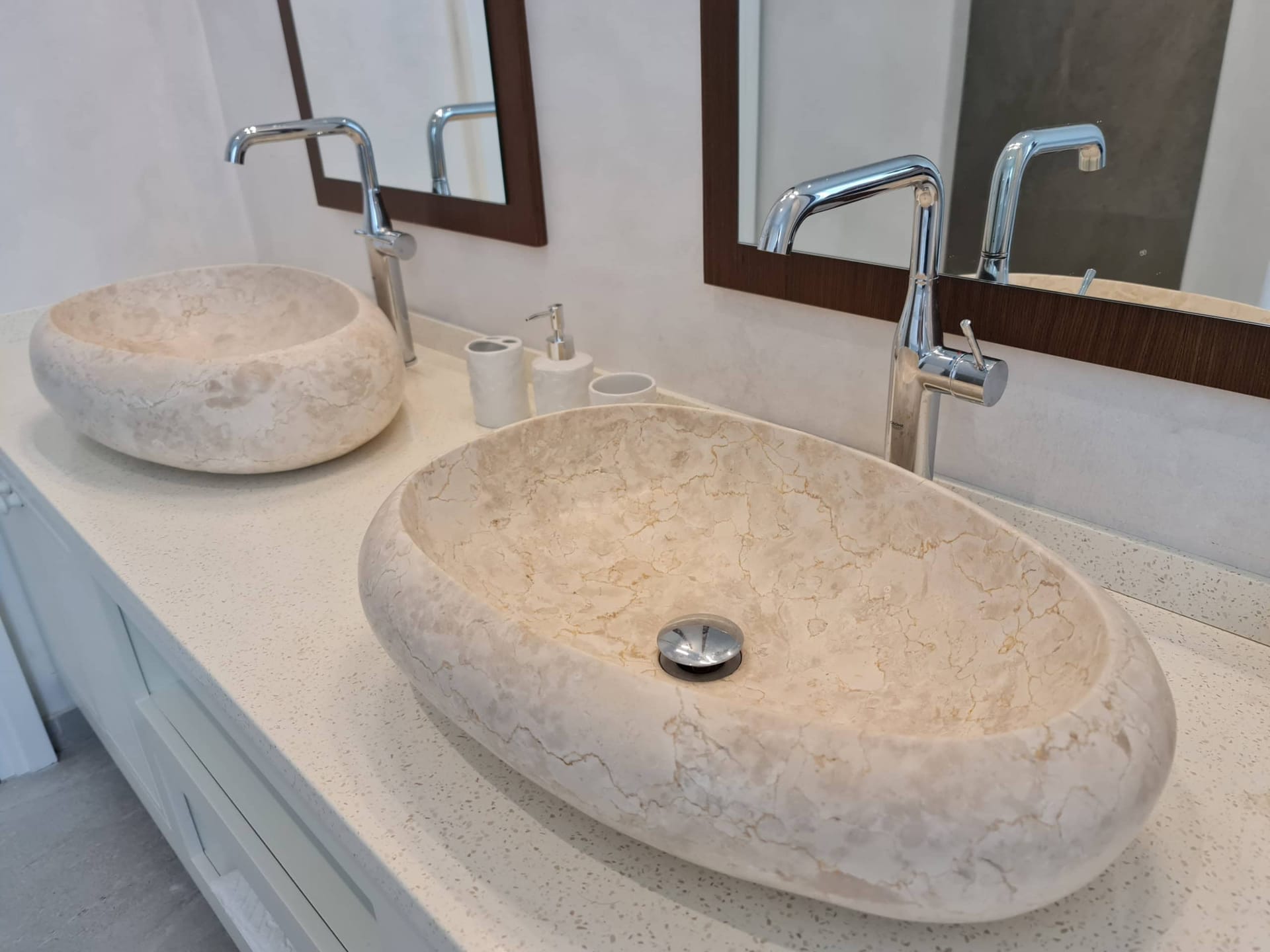 Bathroom with two stone sinks and chrome faucets in a villa in Budva, Montenegro.
