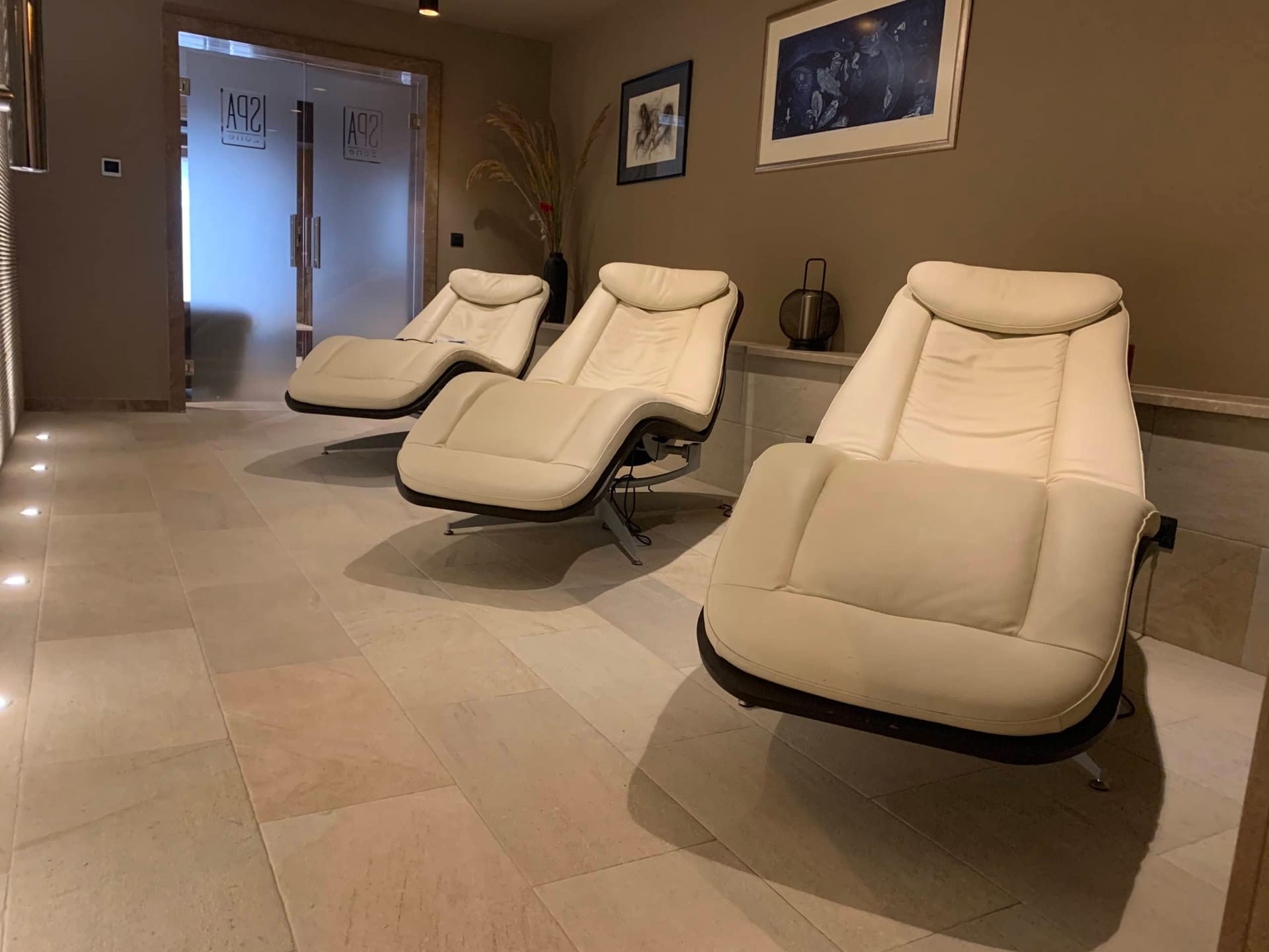 Zona za odmor sa belim kožnim ležaljkama u spa centru stambenog kompleksa u Kumboru, Crna Gora.