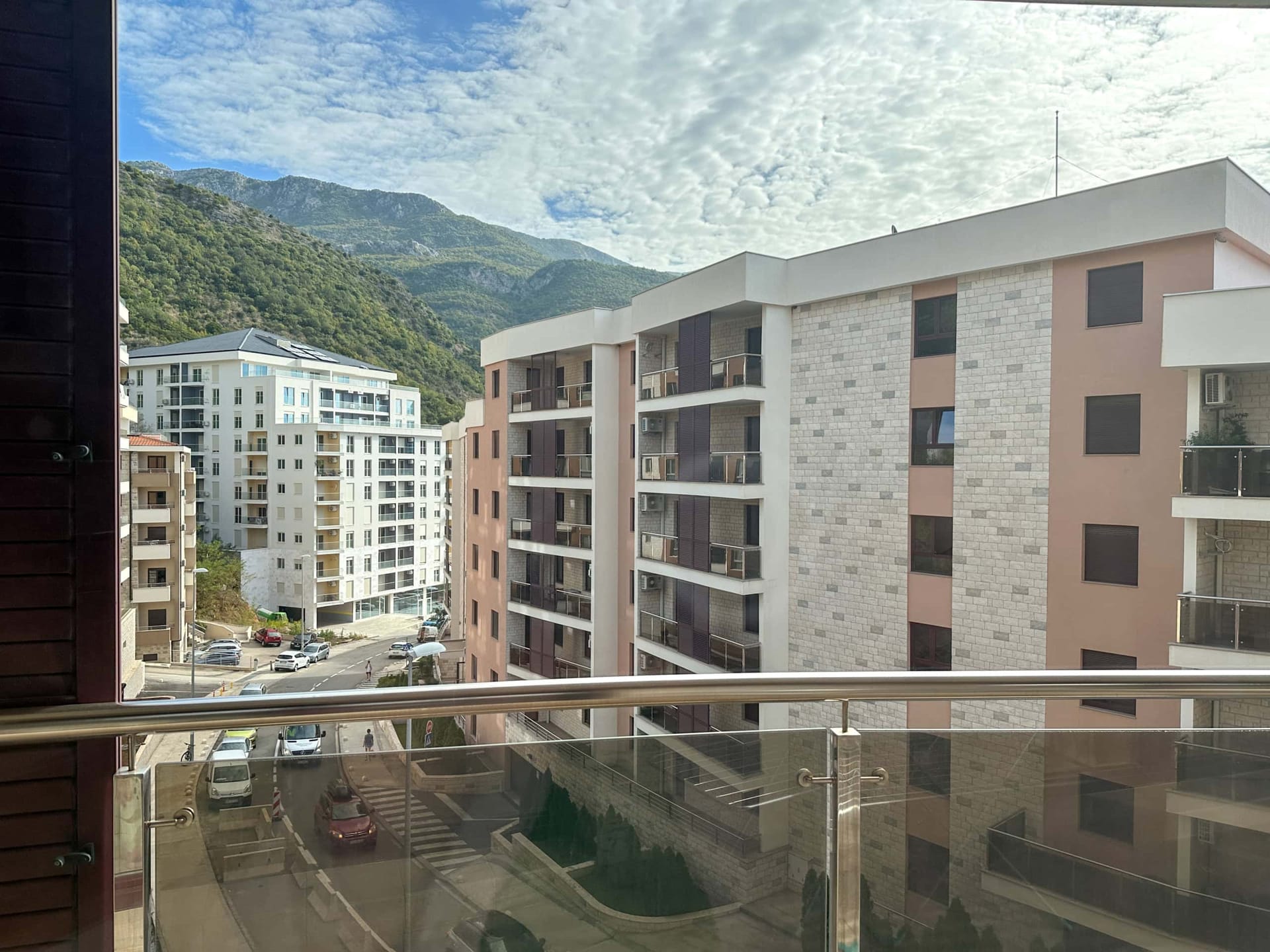 Pogled sa balkona modernog stana u Bečićima, Crna Gora: gradska izgradnja, planine i panoramski pogled na okolinu.
