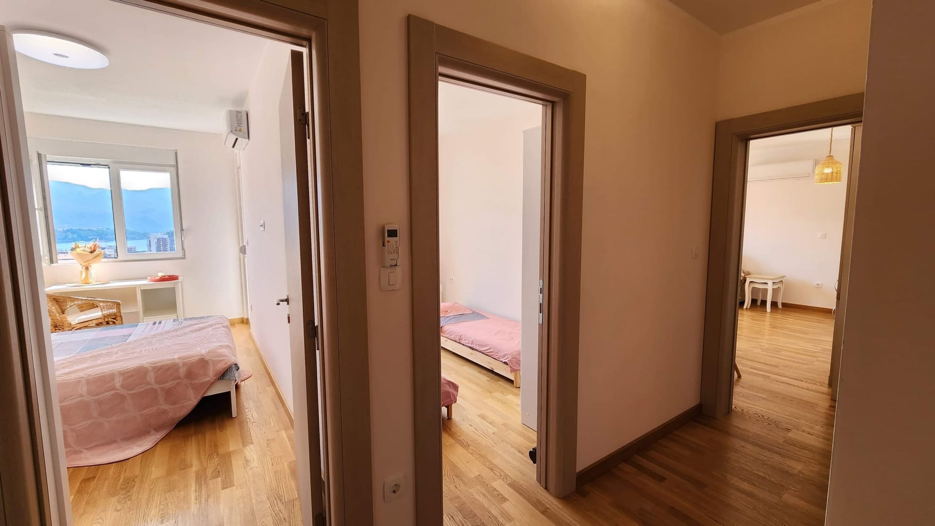 Enterijer stana u Budvi, Crna Gora: svetao hodnik sa izlazom u dve spavaće sobe, parket i pogled na more.