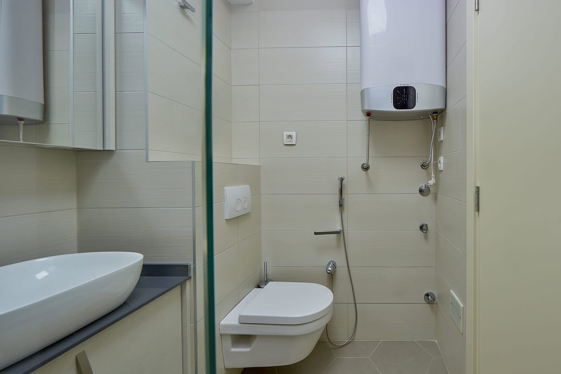 Savremeno kupatilo u stanu, Dobrota, Crna Gora: viseća WC šolja, higijenski tuš i Ariston bojler.
