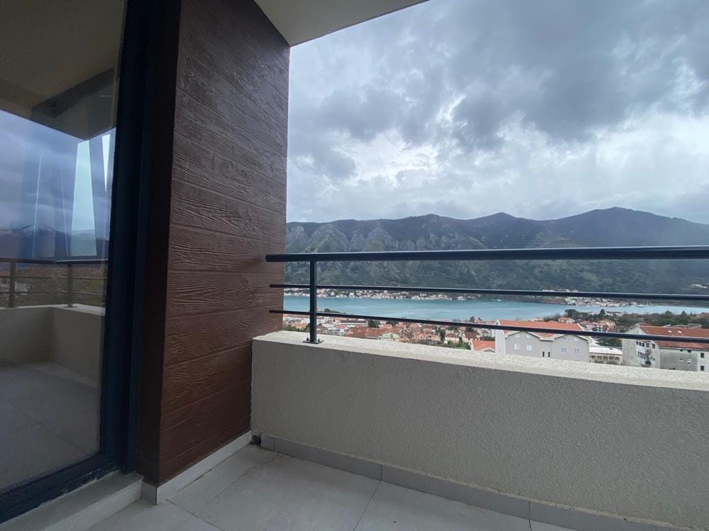 Balkon stana u Dobroti, Crna Gora, sa panoramskim pogledom na Bokokotorski zaliv i planine, moderna fasadna obrada.