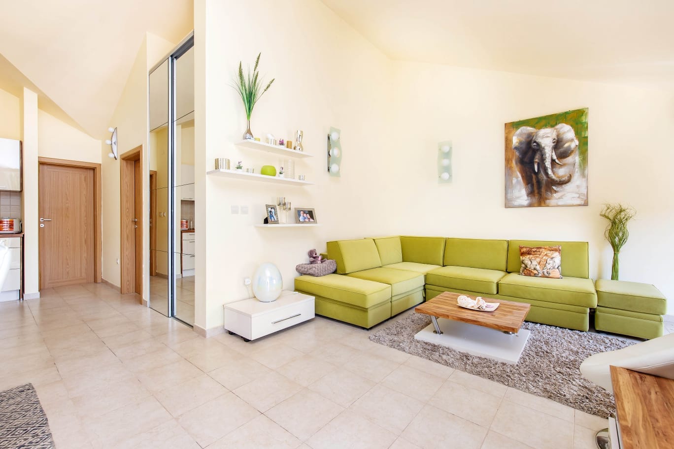 Helles Wohnzimmer mit Ecksofa in einer Wohnung in Đenovići, Montenegro: modernes Interieur und Fliesenboden.