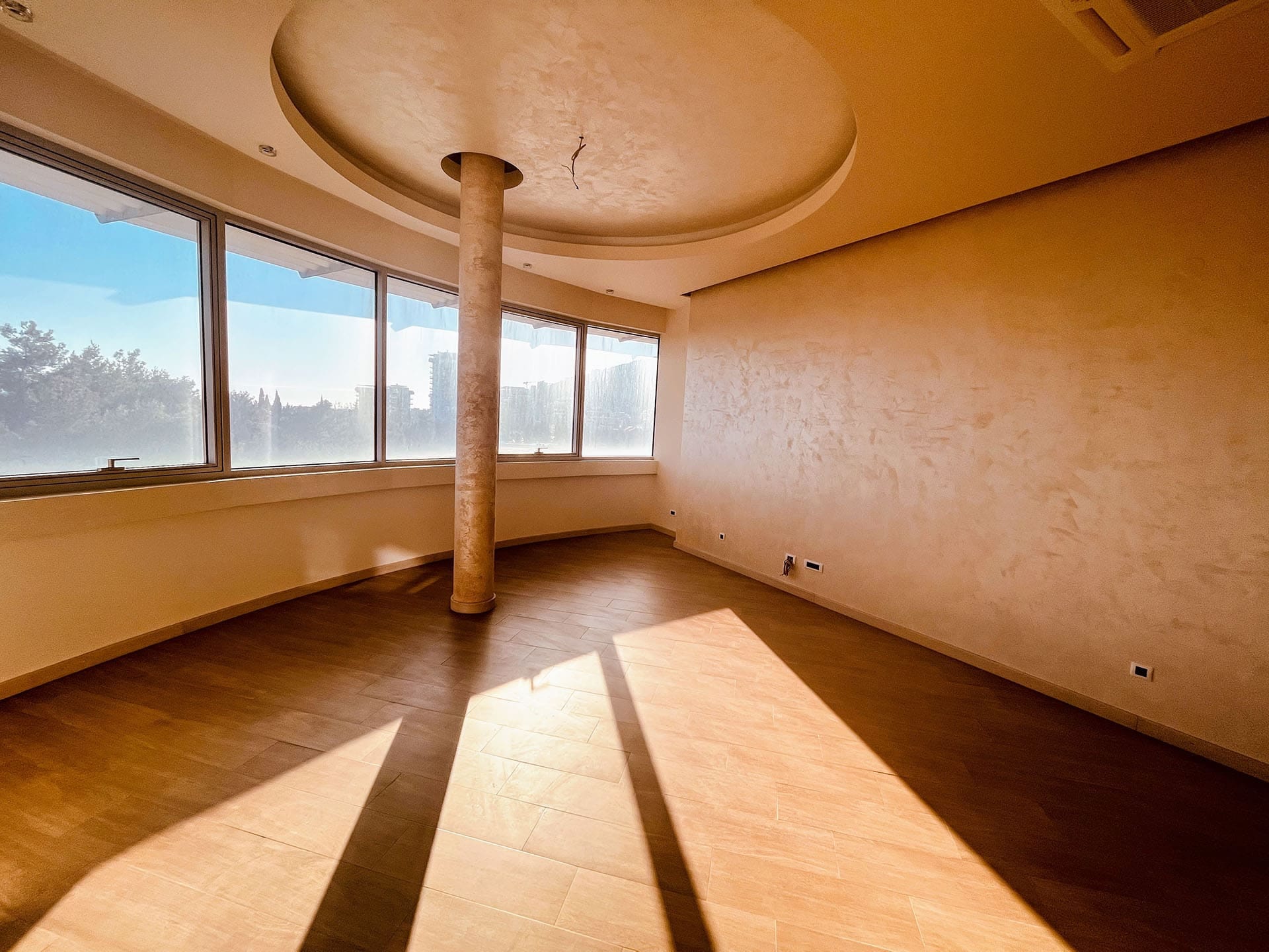 Karadağ, Budva’daki dairede aydınlık oturma odası: panoramik pencereler, декоратив колонна ve loft tarzı duvar kaplaması.