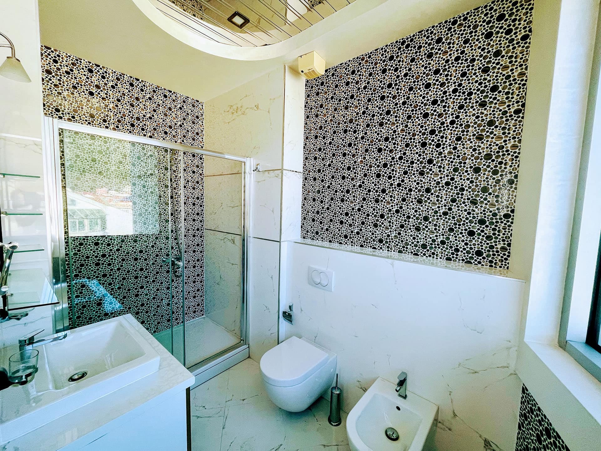 Karadağ, Budva’daki bir dairede modern banyo: duş kabini, mozaik fayans ve kaliteli sıhhi tesisat.