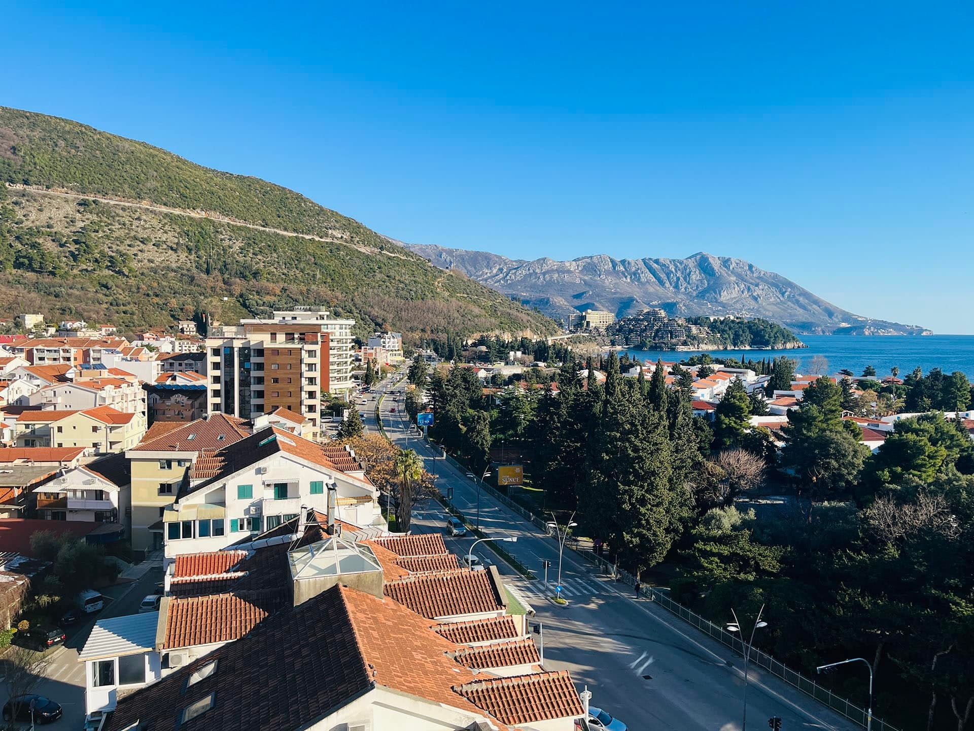 Karadağ’daki bir daireden Budva şehri, dağlar ve Adriyatik Denizi’nin panoramik manzarası, güneşli bir gün.