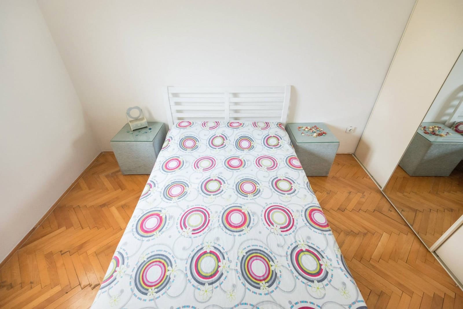 Bedroom with a double bed, parquet flooring, and a wardrobe in an apartment for sale in Dobrota, Montenegro.