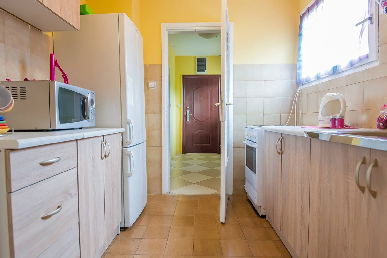 Kitchen with light-colored cabinets and appliances in an apartment, Dobrota, Montenegro.