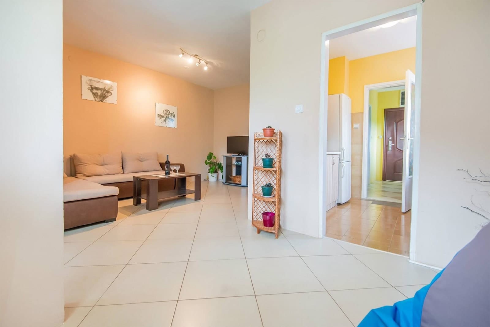 Living room with a soft sofa and kitchen in an apartment, Dobrota, Montenegro: bright interior with tiled flooring.