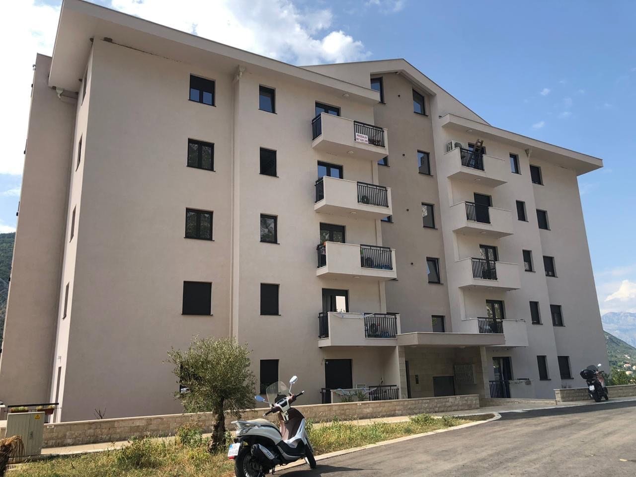 Savremena višespratnica sa balkonima u Dobroti, Crna Gora: fasada zgrade i okolno područje.