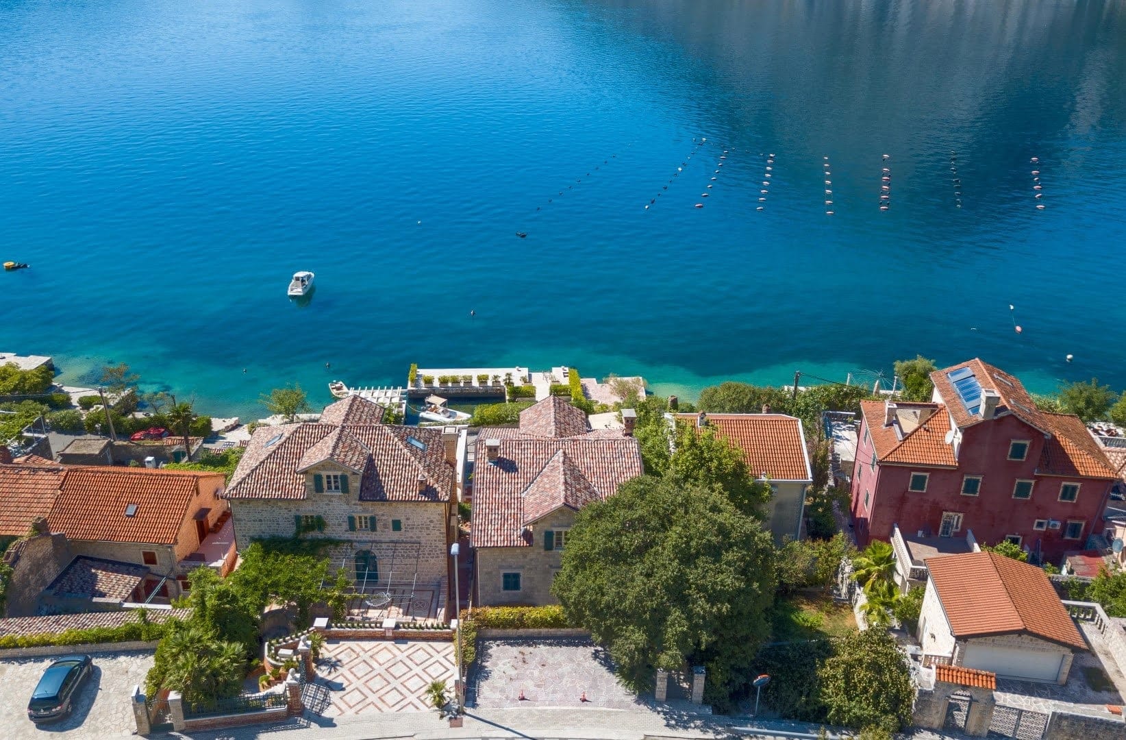 Pogled iz vazduha na kamene vile u Ljuti, Crna Gora, sa izlazom na more, terasama i krovovima od crepova.