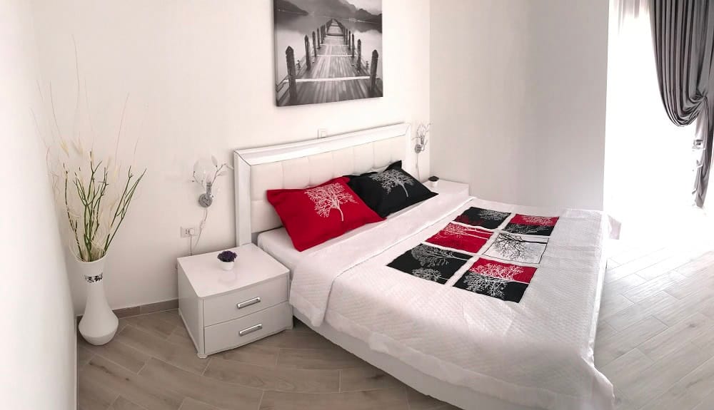 Modernes Schlafzimmer mit weißen Möbeln in einer Wohnung, Dobri Vody, Montenegro: Doppelbett und stilvolle Dekoration.
