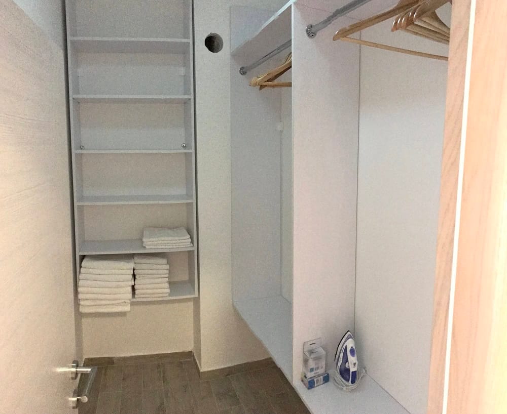 Einbauschrank mit Regalen und Kleiderstangen in der Wohnung, Dobri Vody, Montenegro. Praktisches Aufbewahrungssystem für Kleidung.