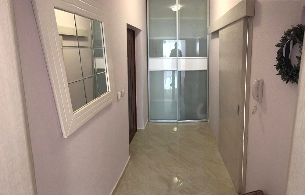 Helle Diele in der Wohnung, Dobri Vody, Montenegro: Einbauschrank, Spiegel und Fliesenboden im Interieur.
