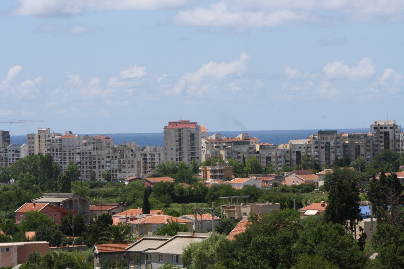 Panoramski pogled na grad Bar u Crnoj Gori: stambene četvrti, zelenilo i morski horizont u pozadini.