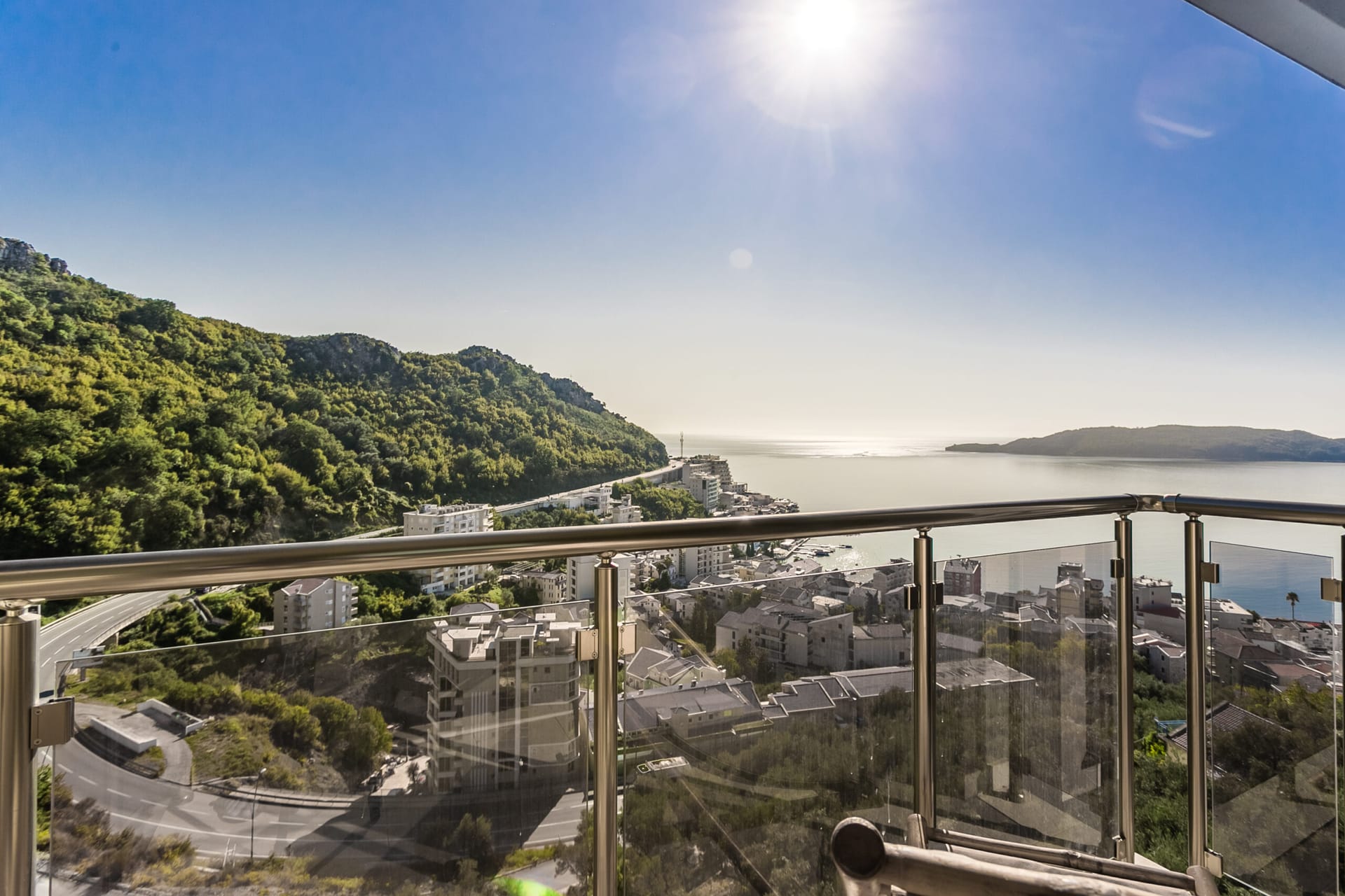 Pogled sa balkona penthausa u Rafailovićima, Crna Gora: panorama Jadranskog mora, planina i grada sa modernim uređenjem.