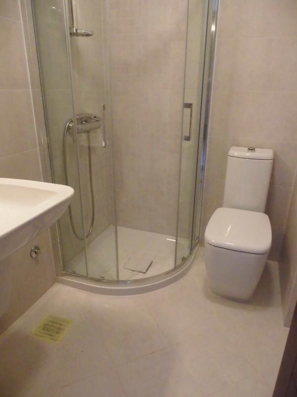 Modern bathroom with a shower cabin in an apartment in Petrovac, Montenegro: light tiles and new fixtures.