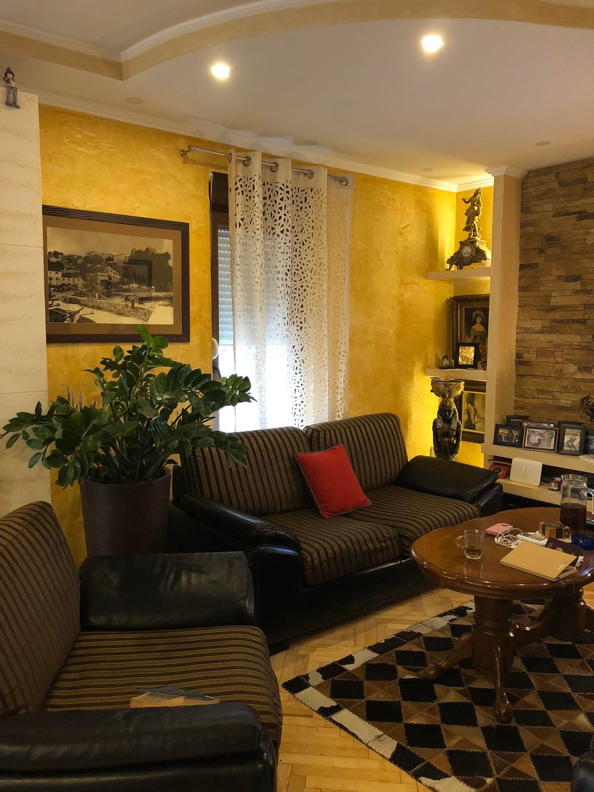 Salon du mini-hôtel Zelenika, Herceg Novi, Monténégro : murs jaunes, canapés rayés, cheminée et décoration intérieure.