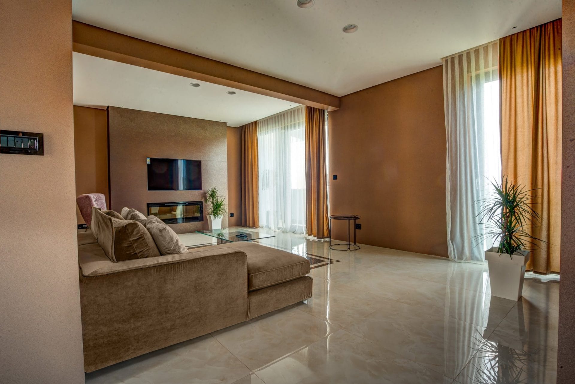Modern living room with a fireplace and a soft sofa in a villa in Budva, Montenegro: stylish interior, panoramic windows.