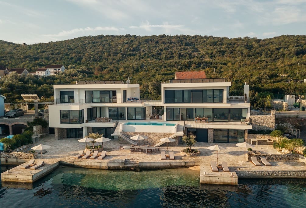 Savremena vila na prvoj liniji u Luštici, Crna Gora: bazen, terasa sa ležaljkama i sopstveni izlaz na more.