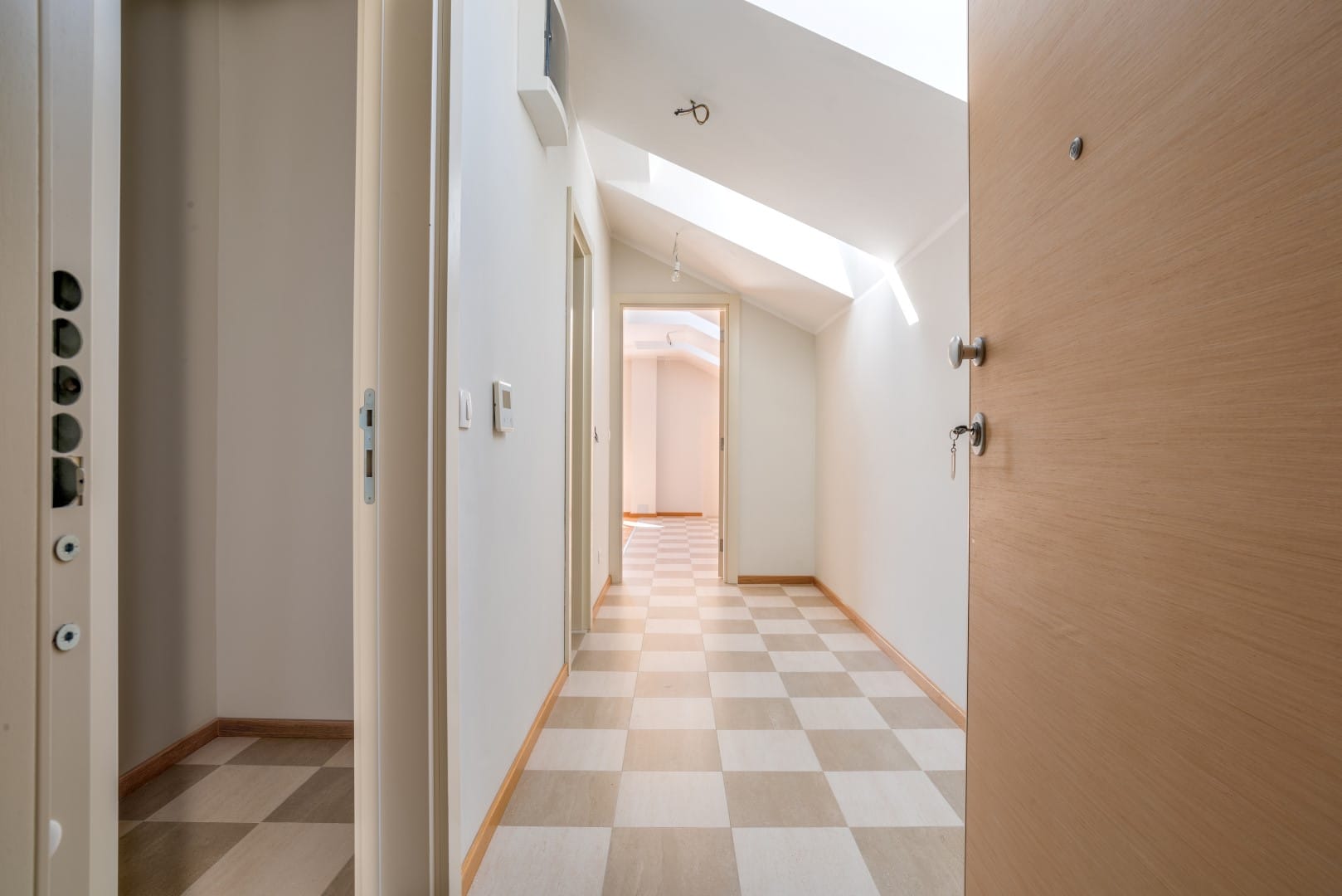 Bright corridor with skylights and a checkerboard floor in a residential complex, Orahovac, Bay of Kotor, Montenegro.