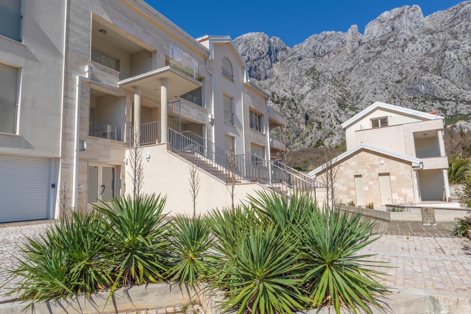 Modern residential complex in Orahovac, Montenegro: light facade, terraces, and views of the mountains of the Bay of Kotor.