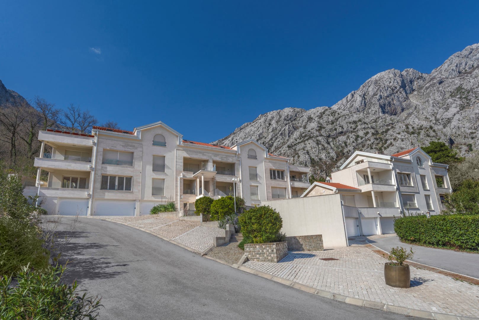 Modern residential complex in Orahovac, Montenegro: light facades, terraces, and views of the mountains of the Bay of Kotor.