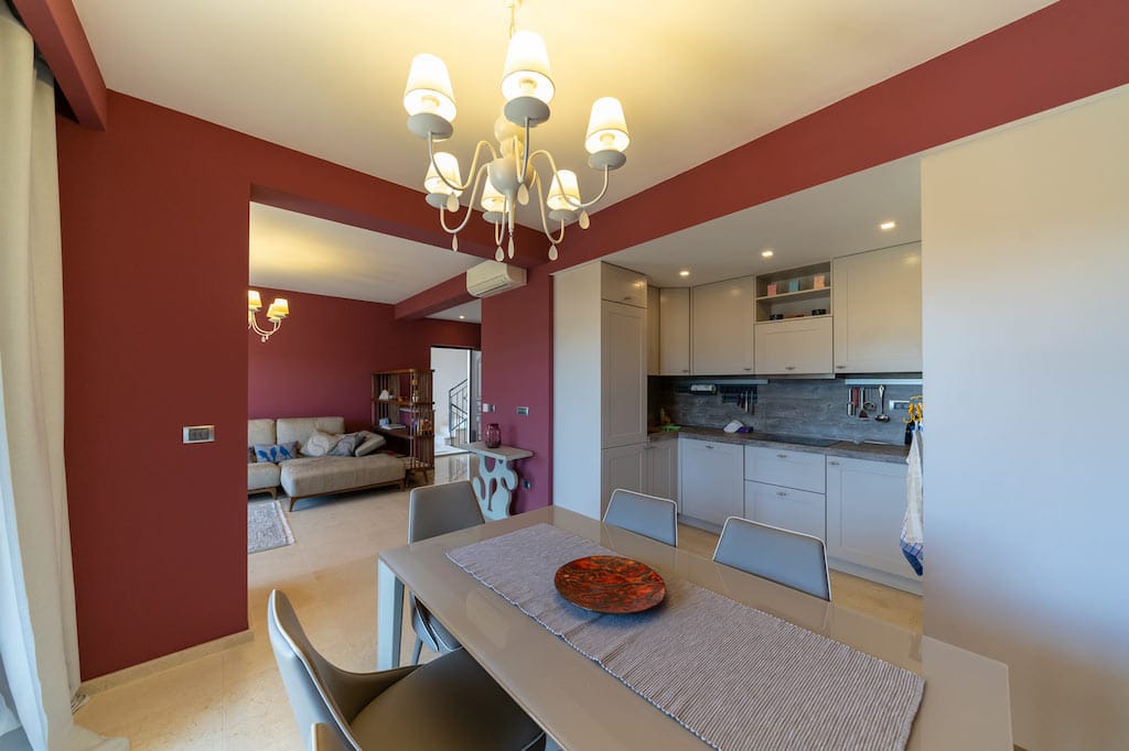 Kitchen-dining room with modern furniture and a living area in an apartment in Petrovac, Montenegro. Interior in burgundy tones.