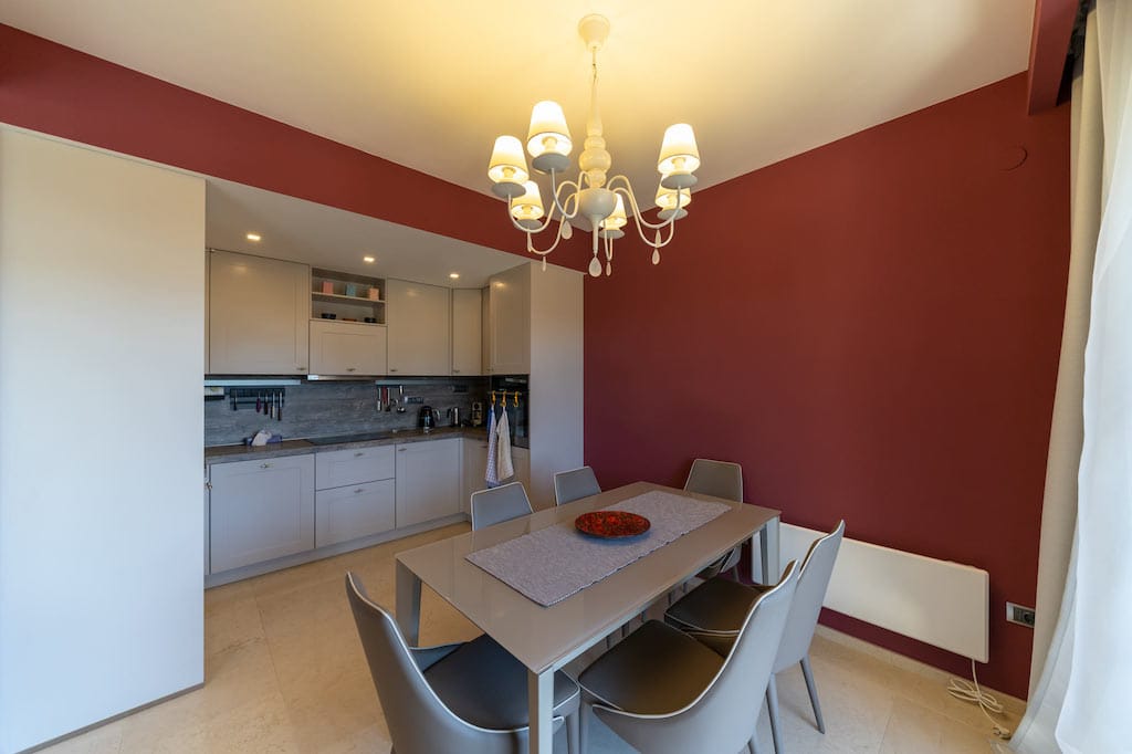 Modern kitchen-dining room with beige cabinetry and dining area in an apartment, Petrovac, Montenegro.